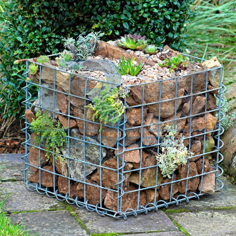 a small gabion planter filled with a rock garden