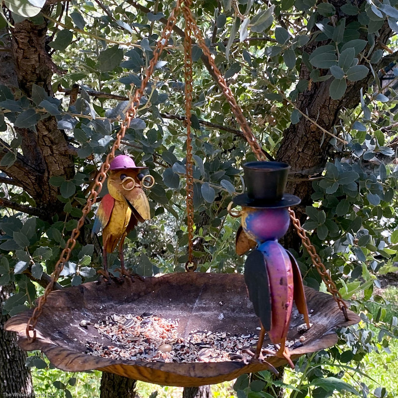 A copper bird feeder or bird bath with two playful keepers.