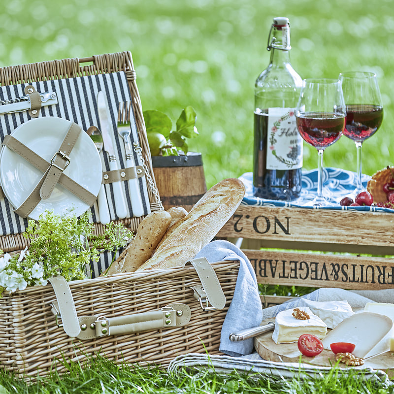 Picnic basket and treats on the grass
