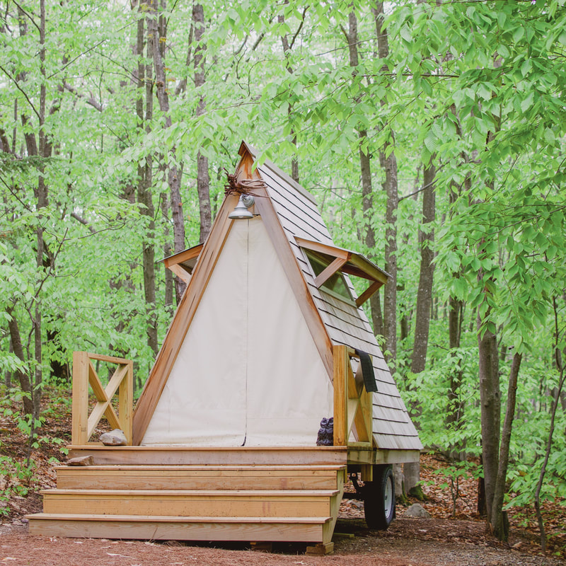 A wooden tent on wheels
