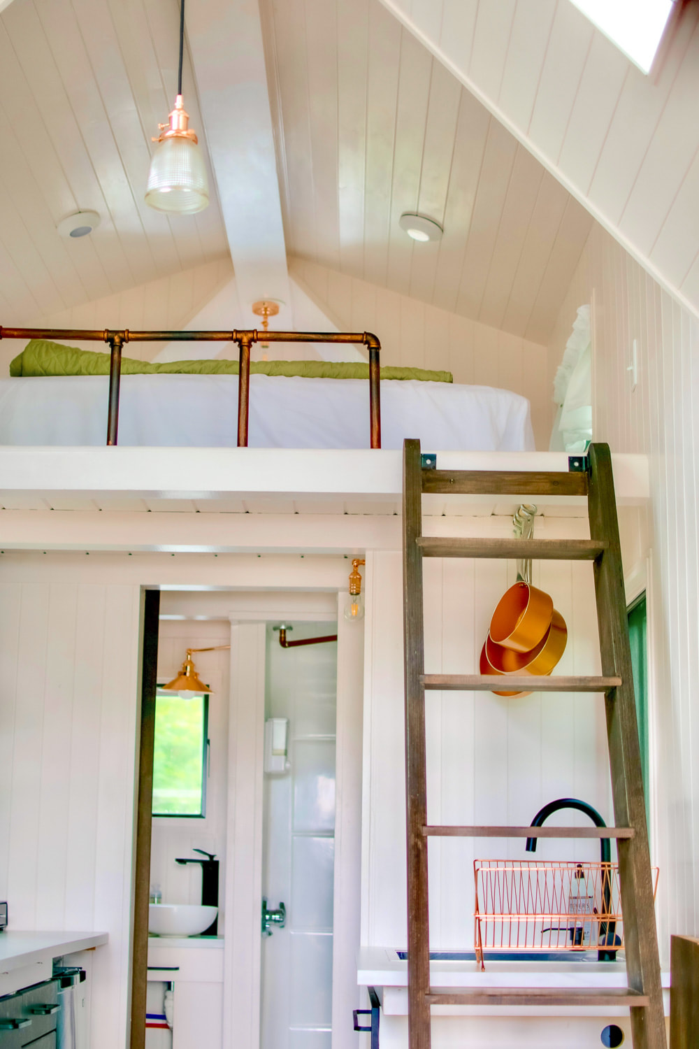 a tiny house with ladder and airy loft