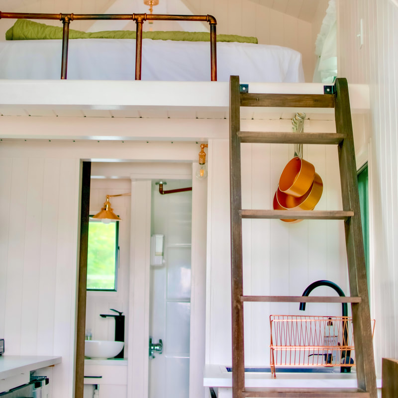 a ladder to a tiny upstairs bedroom loft